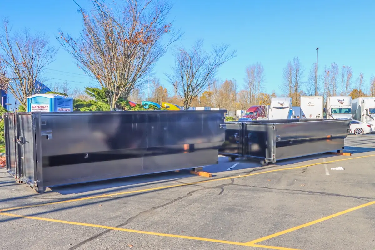 Professional dumpster rental service with roll-off container on residential driveway in Pleasant Garden